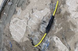 Underfloor heating repair with yellow cable wrapped in tape